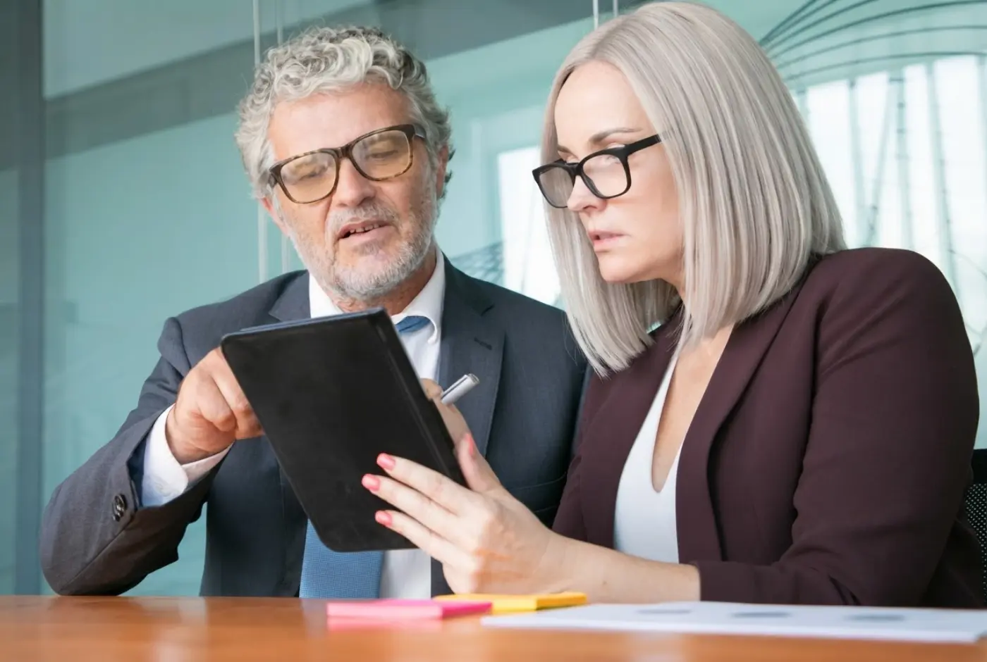 Two colleagues reviewing results on a tablet at a meeting table