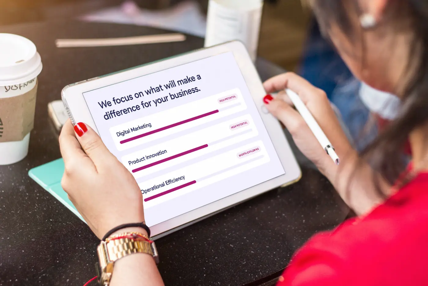Hands with a pen on a tablet showing a ranked list of opportunities