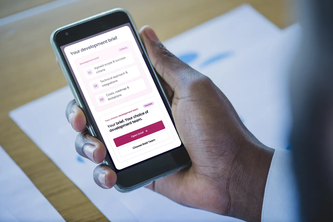 A phone showing a development brief: scope, technical approach and costs