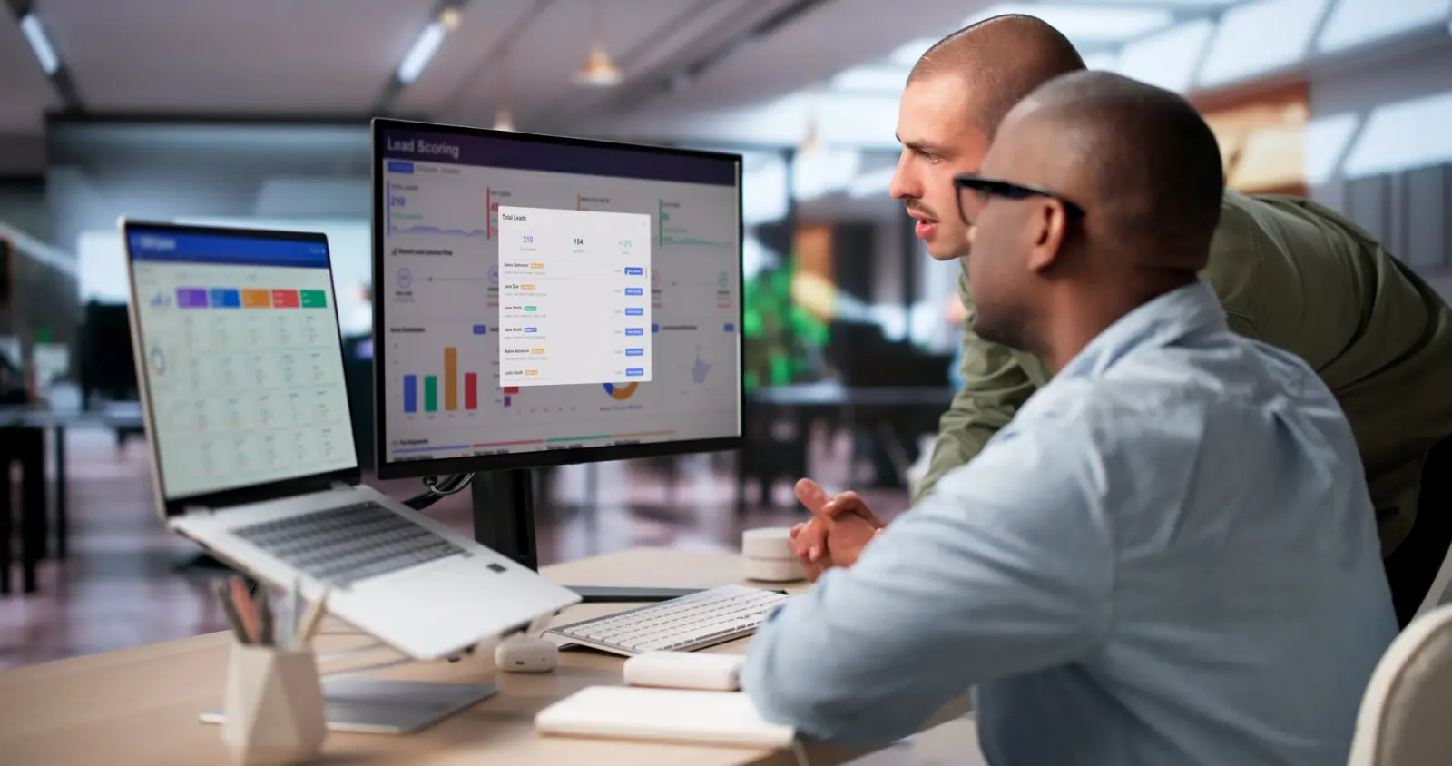Two people at monitors showing dashboards