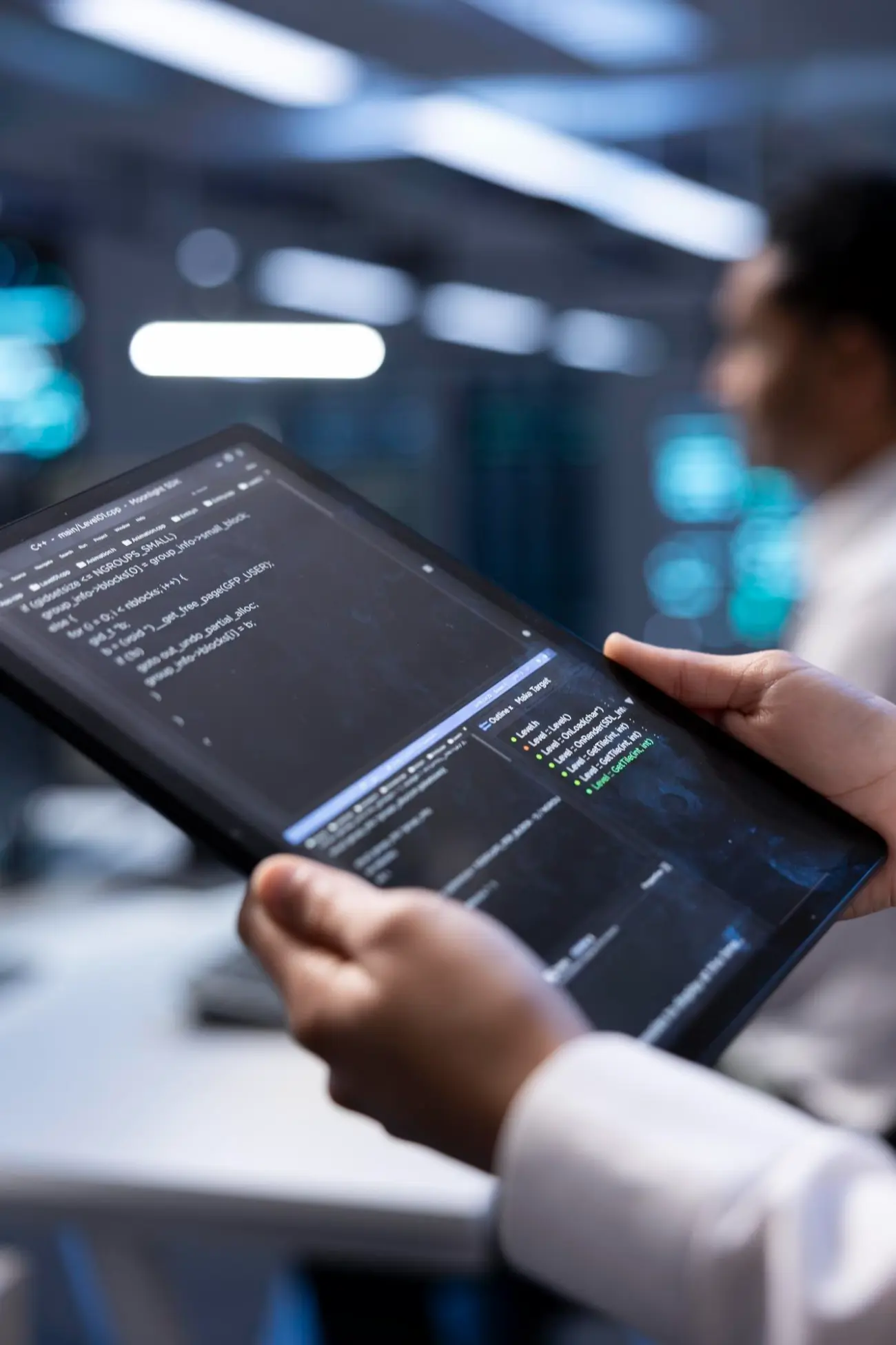 Hands holding a tablet showing code
