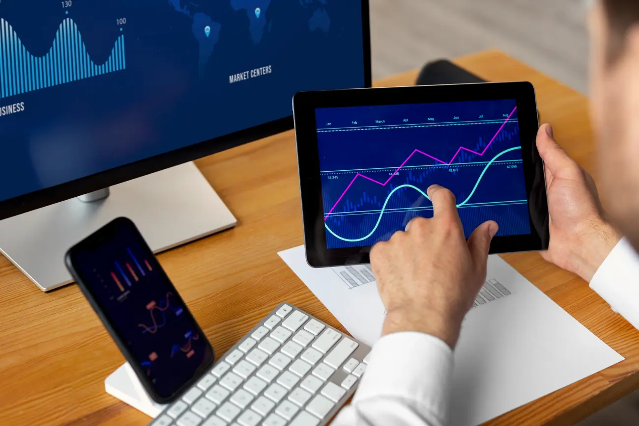 Hands on a tablet showing line charts